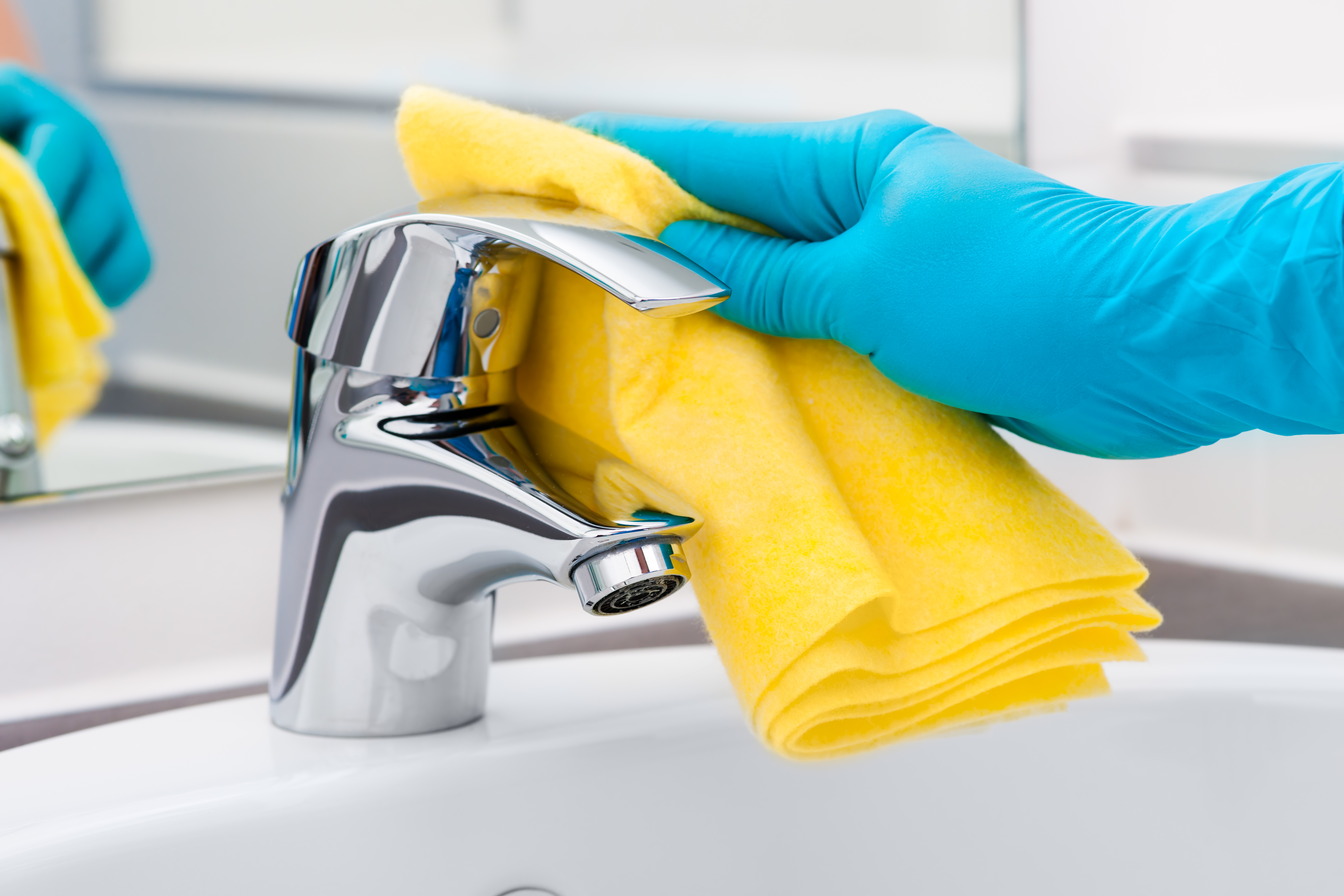 A faucet being cleaned with a yellow cloth, photograph from the official CleanScene Miami website